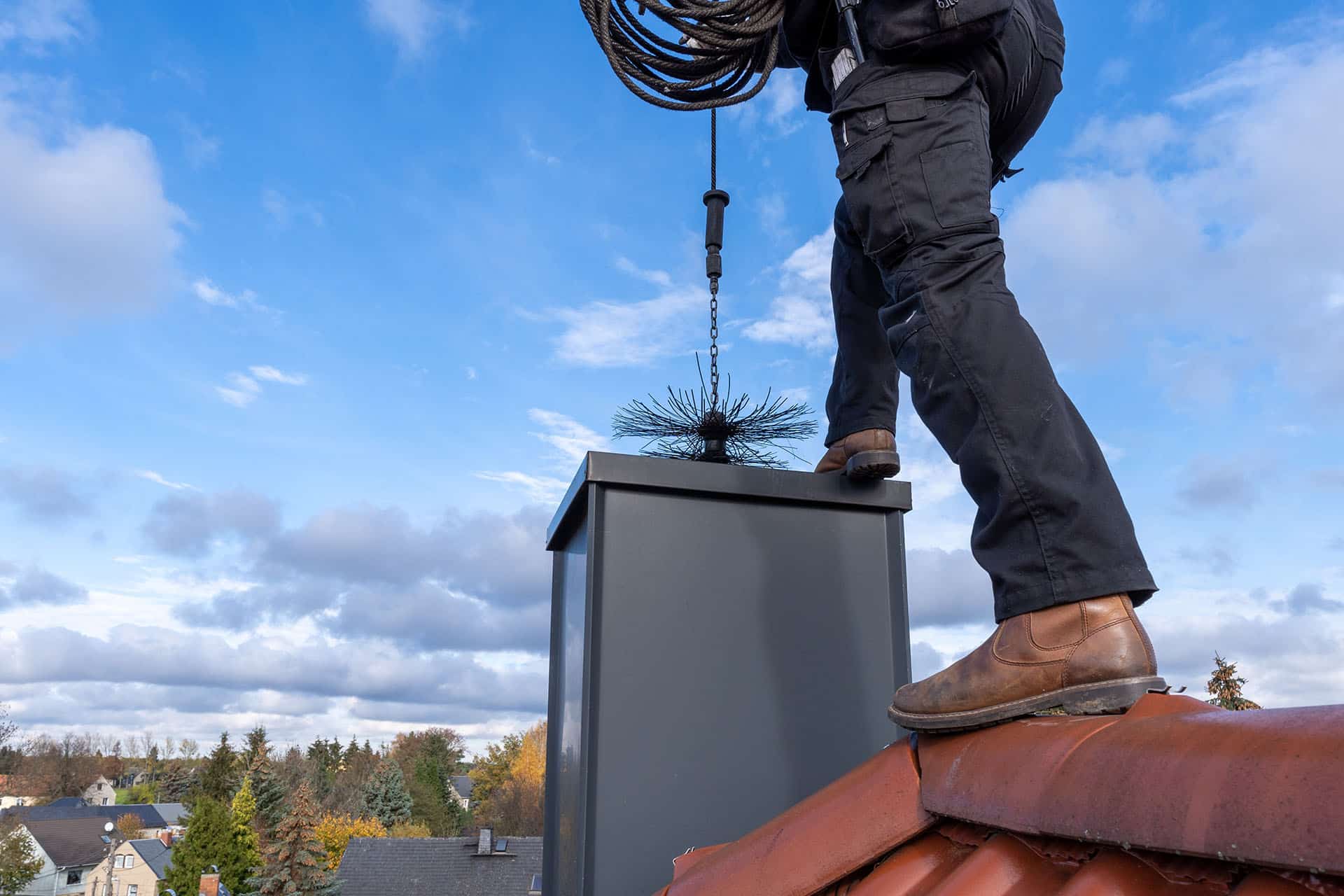 Service technician sweeping chimney