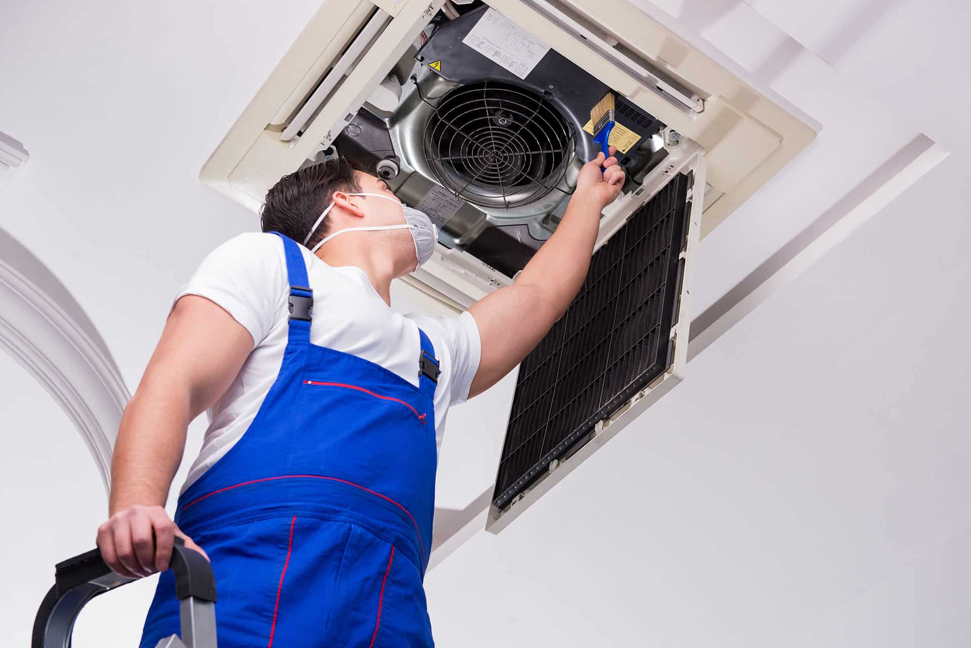 Technician cleaning air conditioning unit