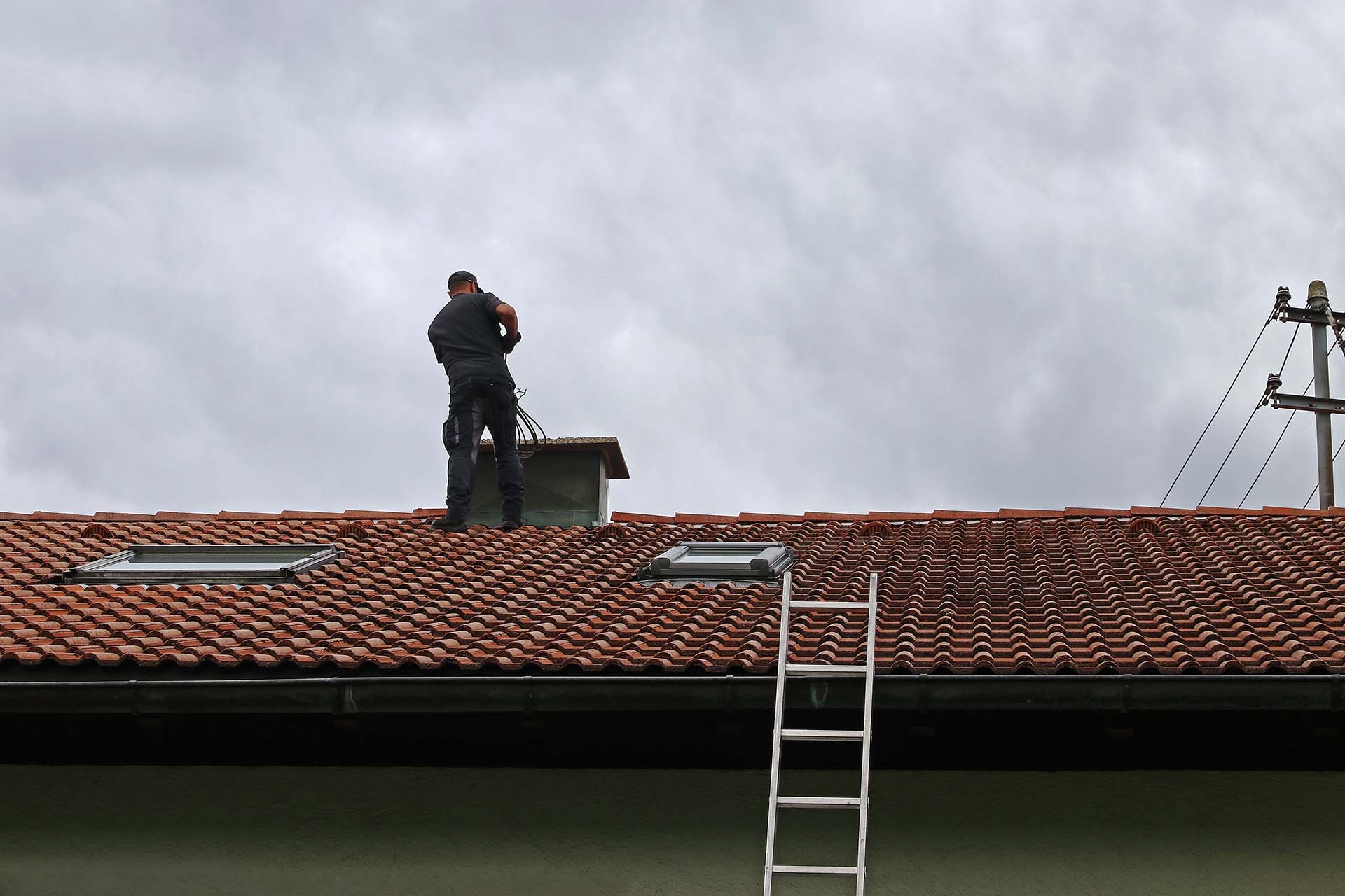 Chimney sweeper standing on roof