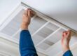 man opening ceiling air vent