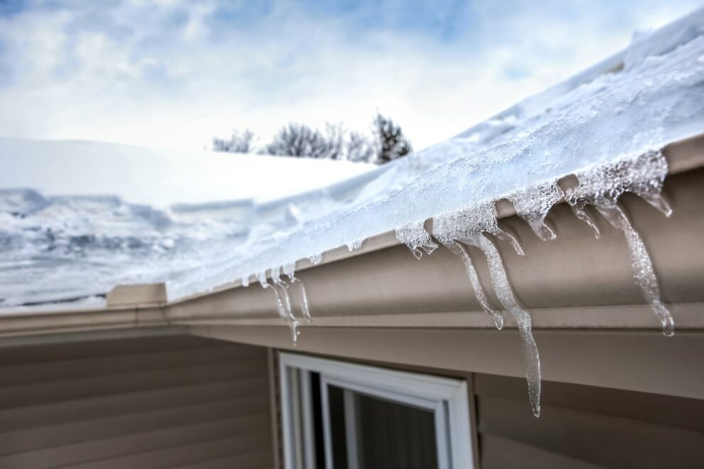 winter snow and icicles on house roof