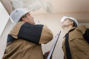 water restoration specialists looking at ceiling