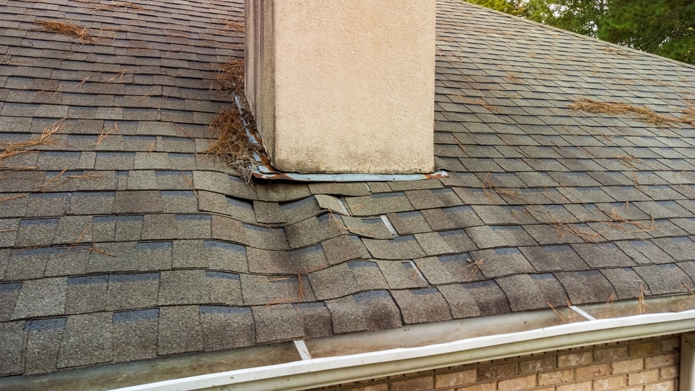 Sagging and wavy roof caused by overflowing gutters and rotten decking.