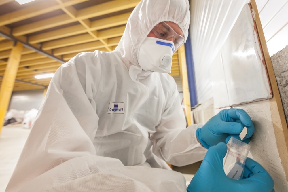 Asbestos surveyor inspecting material